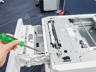 Una mano utilizando un destornillador para abrir la impresora en 10 consejos para solucionar problemas de impresión