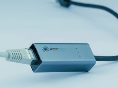 ¿Qué es un Adaptador de Red y para Qué Sirve? 15 Adaptador de red USB-C a Ethernet gris, mostrando el conector USB-C y el cable Ethernet conectado.