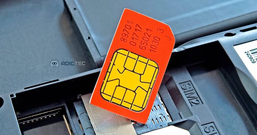 Tarjeta SIM roja siendo insertada en la ranura SIM de un teléfono móvil. Se ven claramente los números de identificación de la tarjeta.