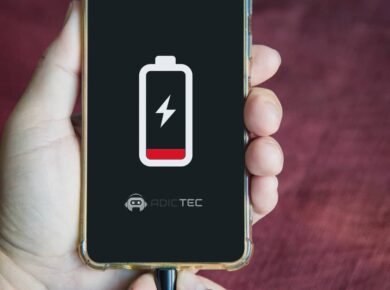 Por qué mi teléfono se descarga rápido: 5 Errores que Matan tu Batería 14 Primer plano de un smartphone con batería baja en pantalla, conectado al cargador para solucionar por qué se descarga rápido.