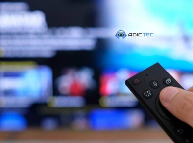 QNED vs QLED vs OLED: Guía Definitiva para Elegir tu TV Ideal 8 Mano sosteniendo un control remoto de TV frente a una pantalla desenfocada, simbolizando la elección de tu TV ideal entre QNED, QLED y OLED.